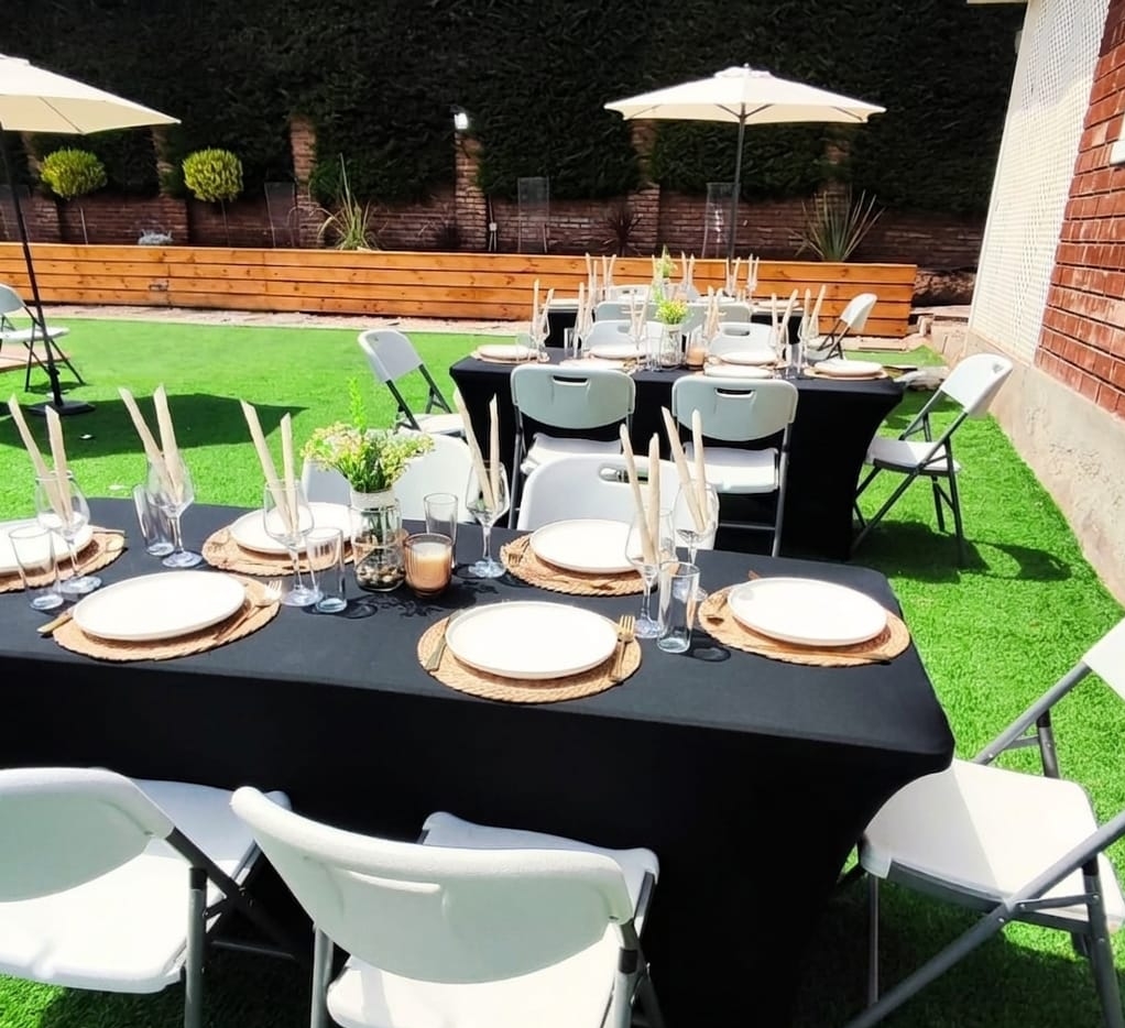 Mesa elegante de matrimonio con vajilla, copas y flores